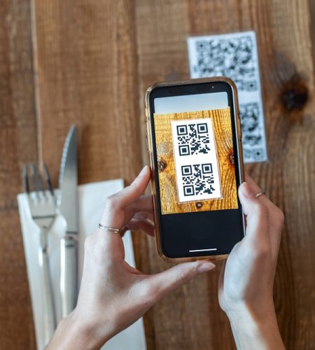 Young woman hands using the smart phone to scan the qr code to s Young woman hands using the smart phone to scan the qr code to s